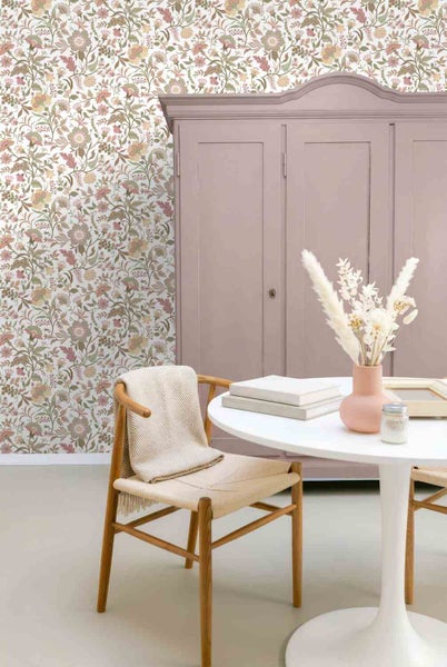 Inneneinrichtung mit floraler Mustertapete, einem hellvioletten Schrank, weißem Rundtisch und einem Holzstuhl.