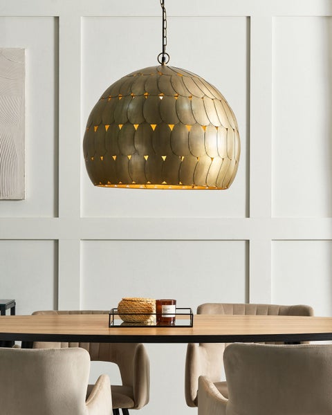 Dekorative Hängeleuchte aus Metall über einem Esstisch mit Stühlen