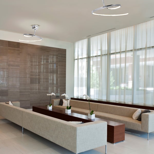 Heller Raum mit Sitzgelegenheiten und zwei modernen Deckenleuchten