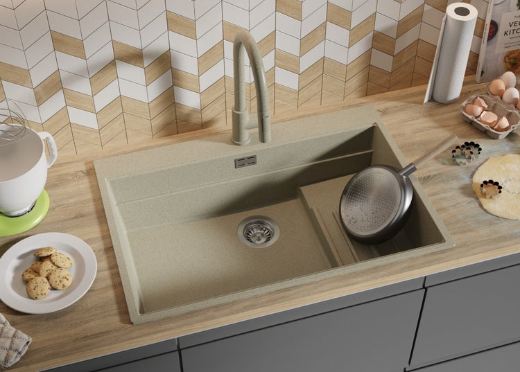 Küchenszene mit Spüle, Armatur und Küchenutensilien auf einer Arbeitsplatte.