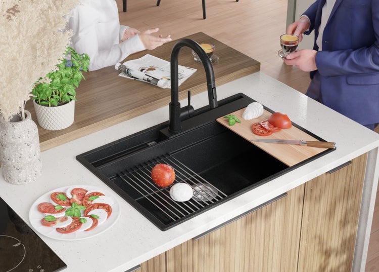 Küchenszene mit schwarzem Spülbecken, Armatur und Zubereitung von Tomaten-Mozzarella-Salat