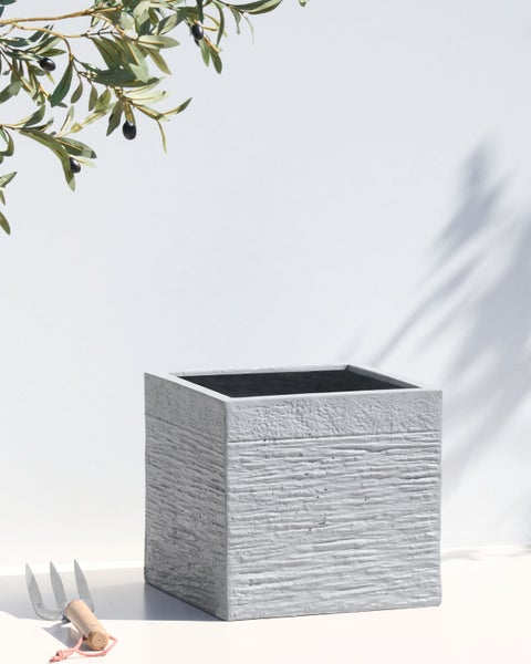 Dekorative Vase mit Punktmuster in Händen