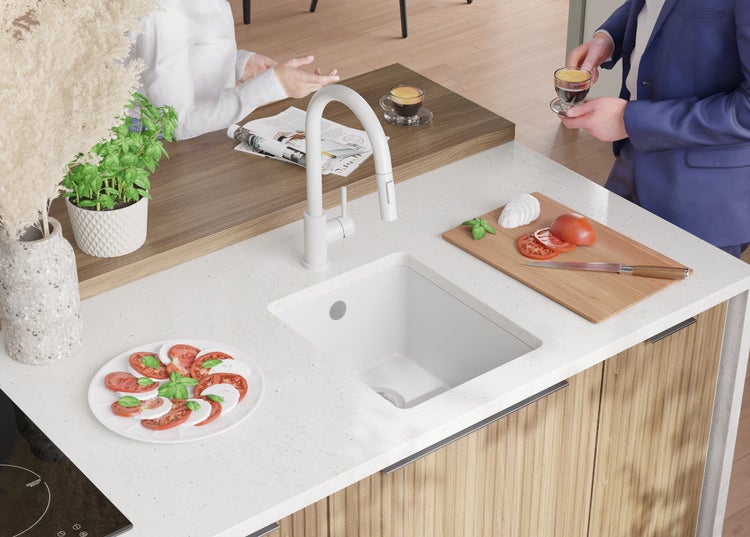 Küchenspüle mit Armatur, Mozzarella-Tomaten-Salat und Person im Anzug mit Kaffeetasse