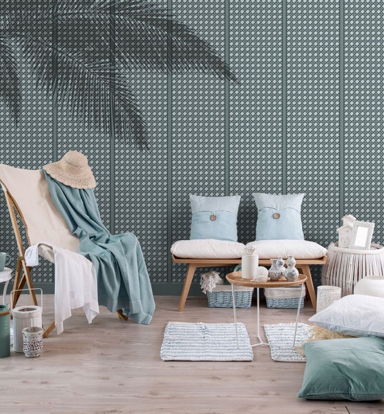 Dekoratives Wohnzimmer mit Strandstuhl und Rattan-Tapete