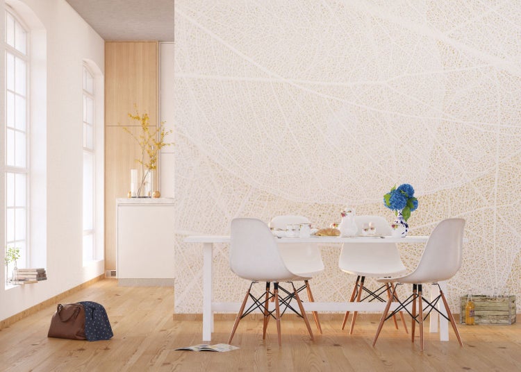 Heller Wohnraum mit Esstisch, Stühlen und Blattmuster-Tapete