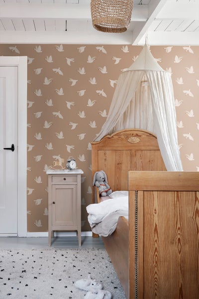 Kinderzimmer mit Holzbett, Nachttisch und Tapete mit Vogelmuster
