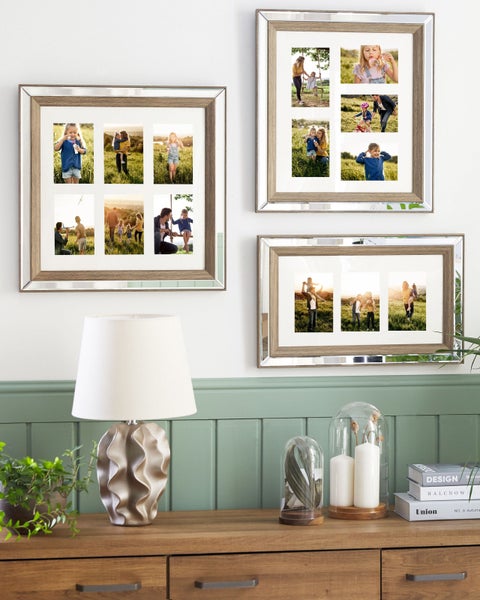 Drei Fotorahmen mit Spiegelrand hängen an einer Wand über einer Kommode mit Dekoration