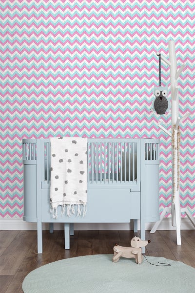 Kinderzimmer mit blauem Kinderbett, Zickzacktapete und Holzspielzeug