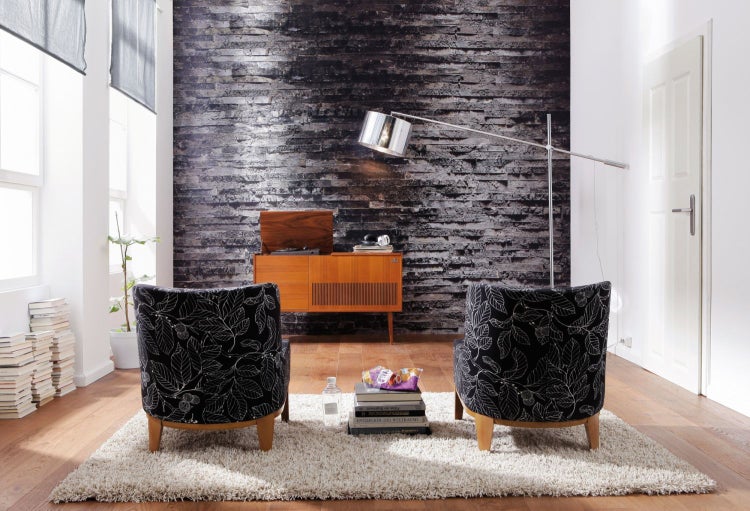 Wohnzimmer mit zwei Sesseln, Teppich und Schallplattenspieler auf Kommode