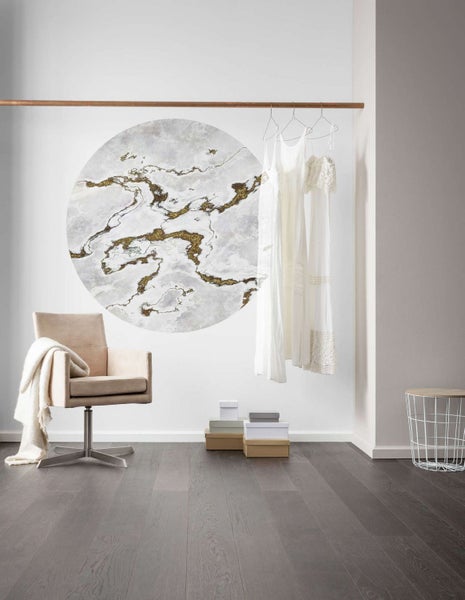 Modernes Interieur mit Stuhl, Kleidern und Dekoration an der Wand