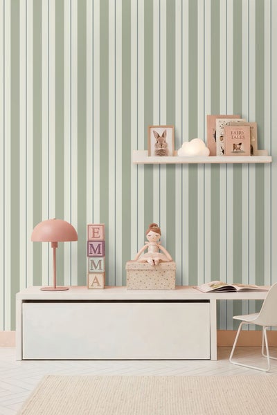 Vertikal gestreifte Tapete in einem hellen Kinderzimmer mit Schreibtisch, Wandregal, Lampe und Spielzeug.