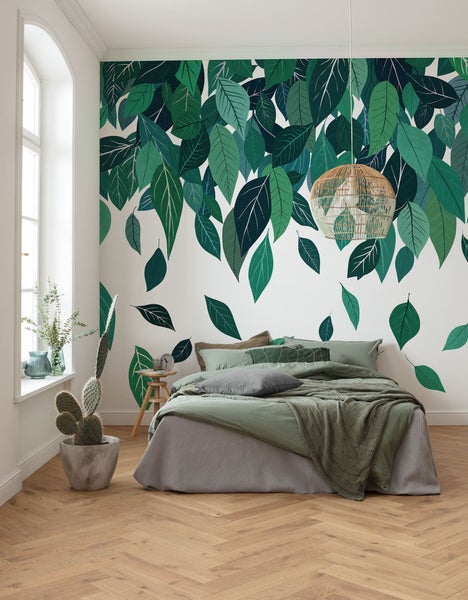 Schlafzimmer mit Wandtattoo mit Blättern, Bett und dekorativer Lampe