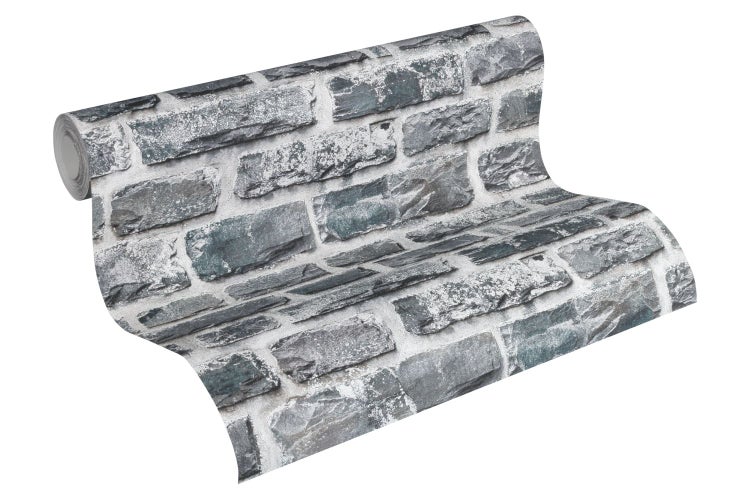 Mann mit Bart im blauen Samtjackett vor einer Ziegelwand