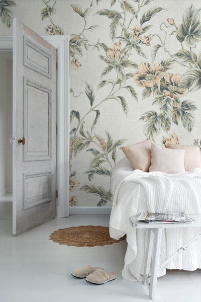 Helles Schlafzimmer mit floraler Tapete, Bett und Tür