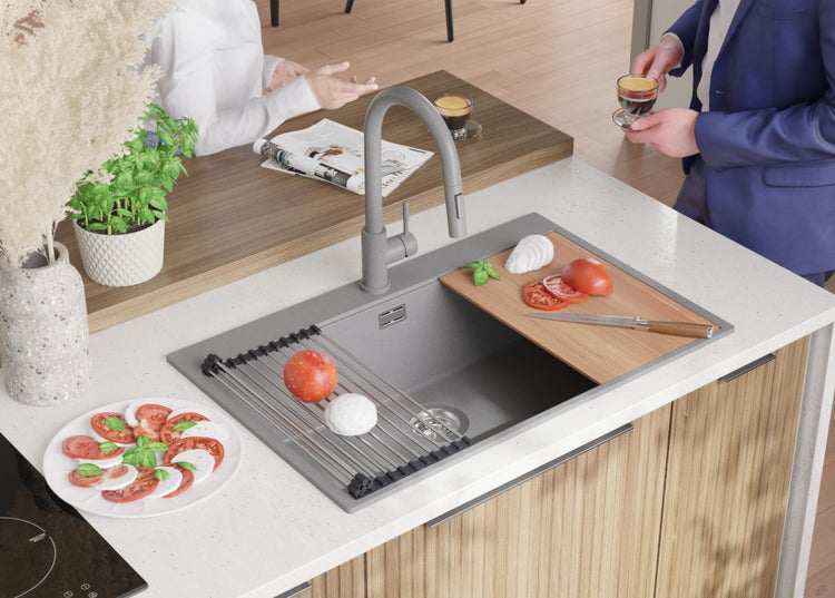Küchenszene mit Spüle, Armatur, Schneidebrett und Lebensmitteln.