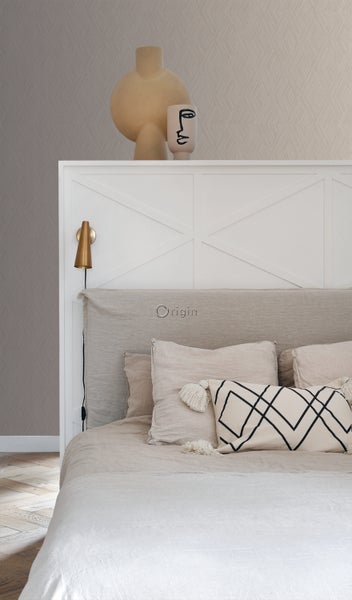 Schlafzimmer mit Bett, Kissen und gemusterter Tapete