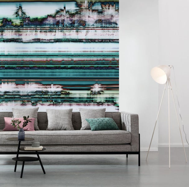 Wohnzimmer mit Sofa, Beistelltisch, Stehlampe und abstrakter Wandtapete mit Palmenmotiv