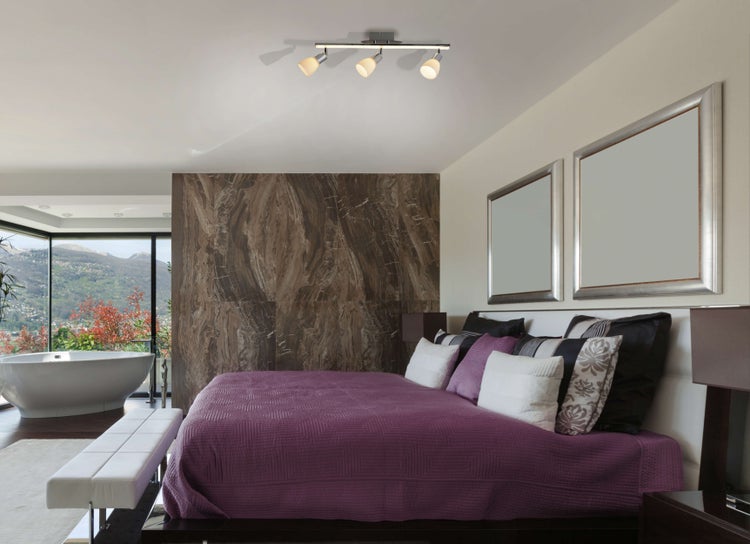 Helles Schlafzimmer mit Doppelbett, Badewanne und Aussicht auf die Berge