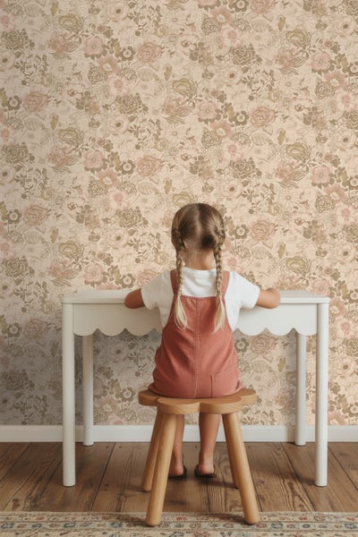Mädchen am Tisch vor Blumentapete