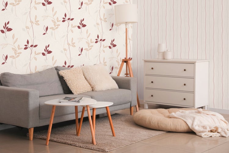 Dekorative Tapete mit Pflanzenmotiven, kombiniert mit einer Topfpflanze und Büchern auf einem Holztisch