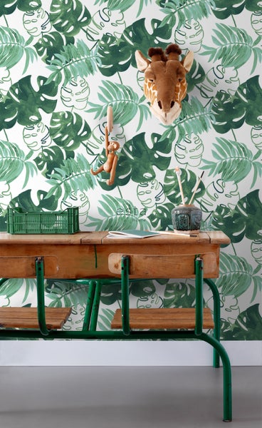 Szene mit einer Schulbank, einem Spielzeugaffen, einem Giraffenkopf und einer Dschungeltapete