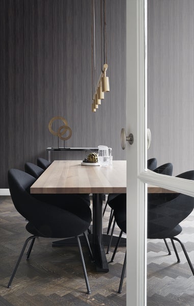 Esszimmer mit Esstisch, Stühlen, Pendelleuchte und dekorativen Elementen.