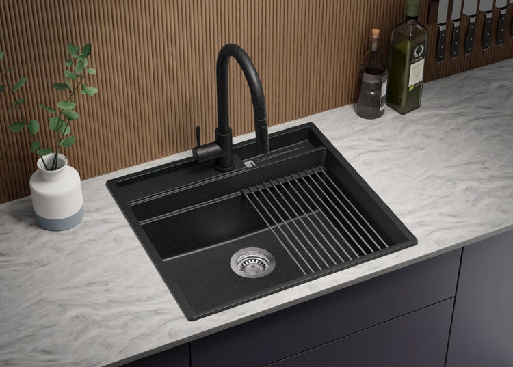Schwarze Küchenspüle mit Abtropfgestell und Armatur auf einer Küchentheke