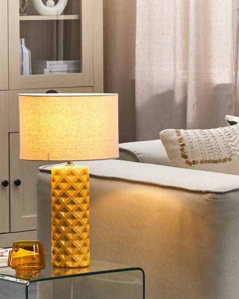 Wohnzimmer-Szene mit Sofa, Sessel, Beistelltisch, Lampe und Teppich für eine gemütliche Atmosphäre