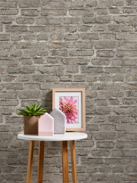 Dekoratives Sofa mit Holzrahmen und Stoffbezug vor Ziegelwand