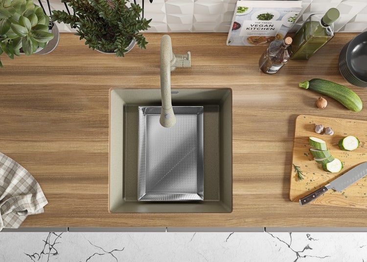 Küchenspüle mit Abtropfschale, Armatur, Schneidebrett, Kochbuch und Pflanzen auf einer Arbeitsplatte