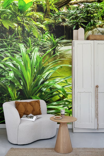 Dekoriertes Wohnzimmer mit Dschungel Tapete, Sessel und Beistelltisch