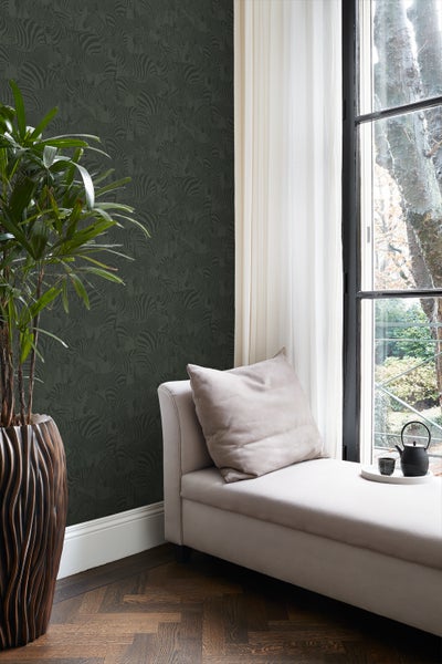 Einrichtungsbeispiel mit gemusterter Tapete, Liege, Topfpflanze und Fenster