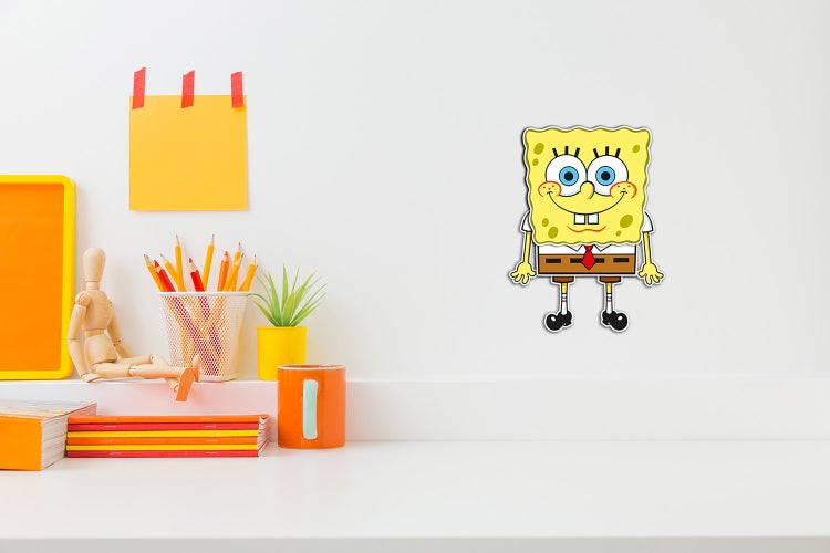 Wandsticker SpongeBob Schwammkopf in einem Kinderzimmer über einem hellen, organisierten Schreibtisch mit Schreibutensilien.