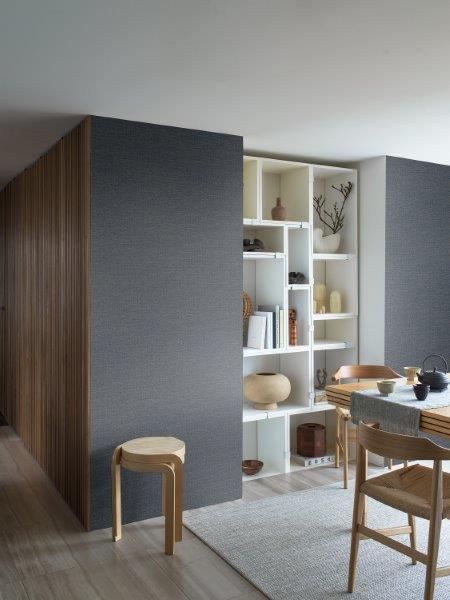 Blumentapete mit floralem Muster hinter einem Schreibtisch mit Notizbuch und Stiften