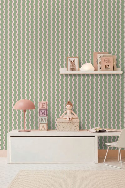 Hell eingerichtetes Kinderzimmer mit Wellenmuster-Tapete, weißem Sideboard, rosa Schreibtischlampe, Holzbausteinen und Wandregal.