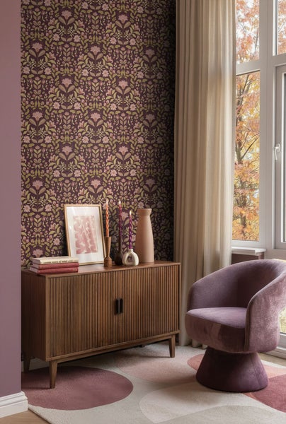 Dekoratives Wohnzimmer mit floraler Tapete, Kommode und Sessel