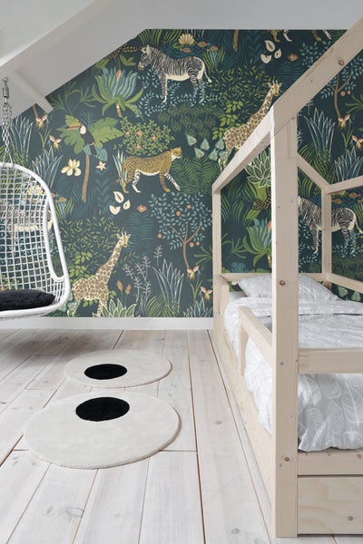 Kinderzimmer mit Holzbett, Hängesessel und Dschungeltapete mit Zebra-, Leoparden- und Giraffenmotiven