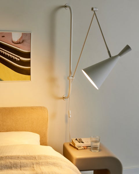 Schlafzimmer mit Wandleuchte, Bett und Nachttisch