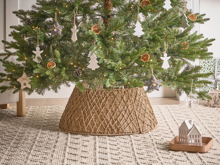 Geschmückter Weihnachtsbaum mit Baumständer, Christbaumschmuck und Weihnachtsdekoration auf Teppich