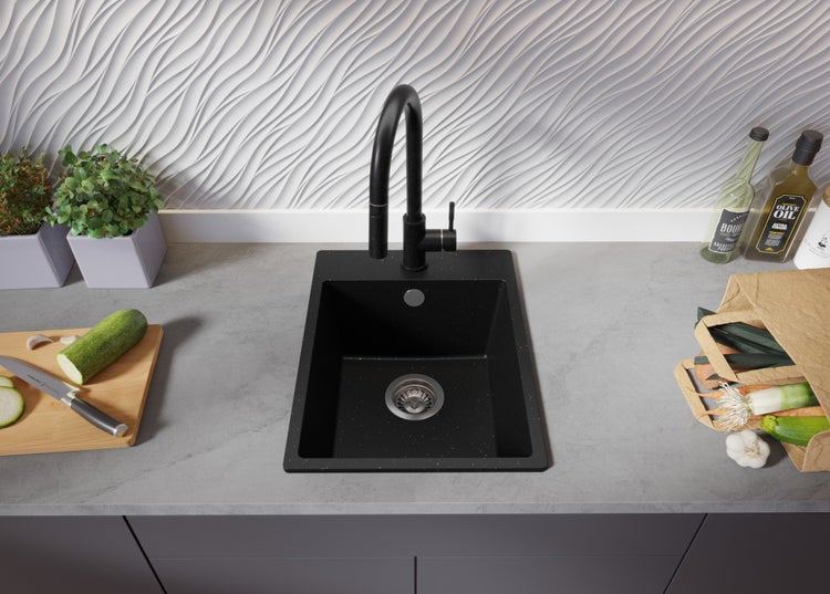 Küchenszene mit schwarzer Spüle, Armatur, Gemüse und Kräutern