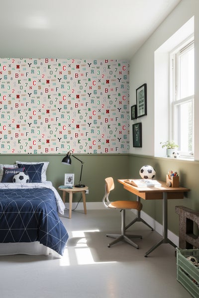 Jugendzimmer mit Bett, Schreibtisch und einer mit Zahlen und Buchstaben bedruckten Tapete