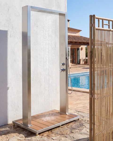 Moderne Gartendusche aus Edelstahl mit Regenduschkopf, Handbrause und Bodenplatte in Holzoptik neben einem Pool.