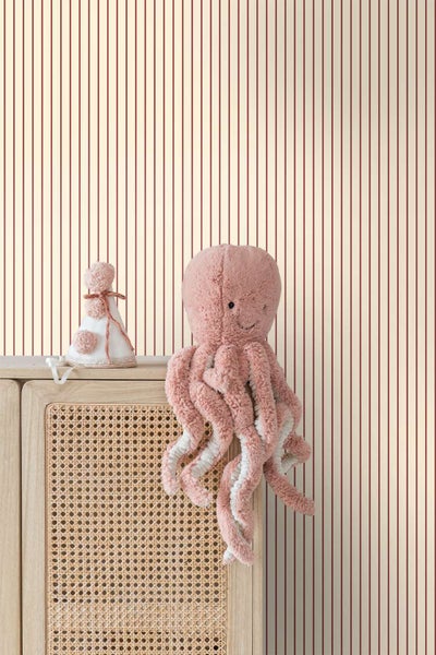 Vliestapete mit feinem Streifenmuster in einem Kinderzimmer mit Holzkommode und Stofftier