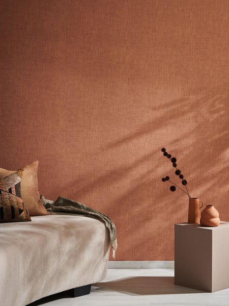 Dekorative Szene mit zwei Keramikvasen und floralen Elementen auf einem Tisch vor einer strukturierten Wand