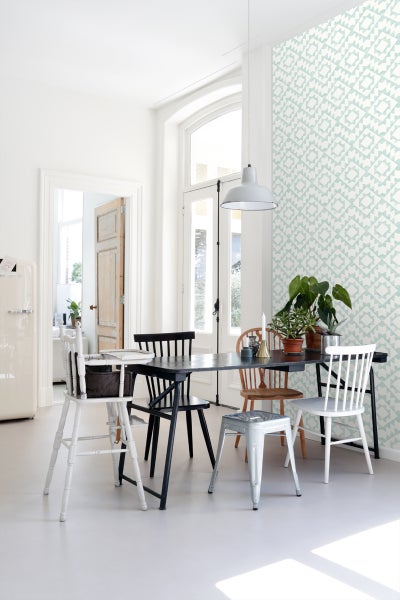 Heller Raum mit Esstisch, Stühlen und gemusterter Tapete