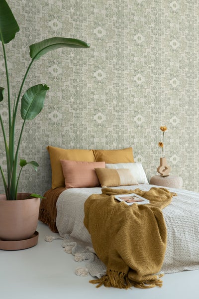Schlafzimmer mit gemusterter Tapete, Bett und Zimmerpflanze