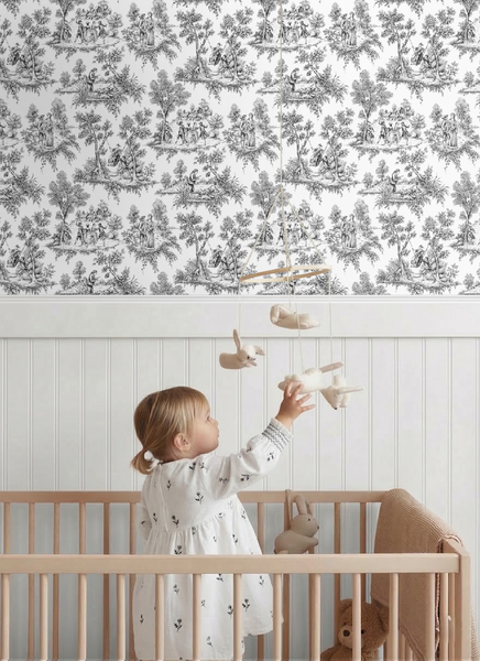Vliestapete Toile de Jouy im Kinderzimmer mit weißer Wandpaneele und Holzgitterbett.