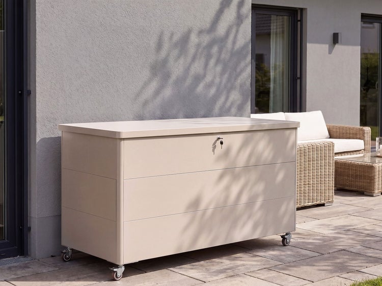 Gartenbox mit Rollen und Schloss vor einer Hauswand auf einer Terrasse stehend.
