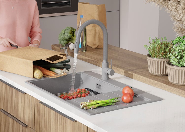 Spültisch mit Armatur, Gemüse und Person in der Küche