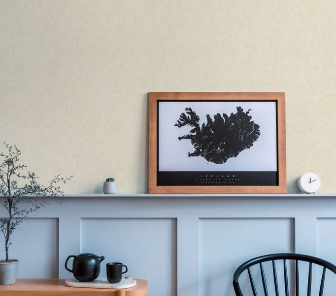 Schlafzimmer mit Wandleuchte, Kommode und Bett in Grautönen.